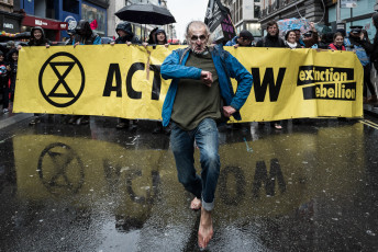 Thousands of rebels march on Oxford Street, one of London's shopping streets during the funeral march organized to express their grief and despair over climate change. Behind the banner with "Act Now" written on it, activists declare: "We unite in grief, anger and love of life on Earth". London 12 October 2019.